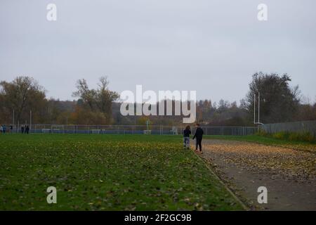Two little kids walking on a field on a gloomy day Stock Photo