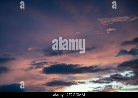 Colorful clouds in dramatic sky at sunset Stock Photo