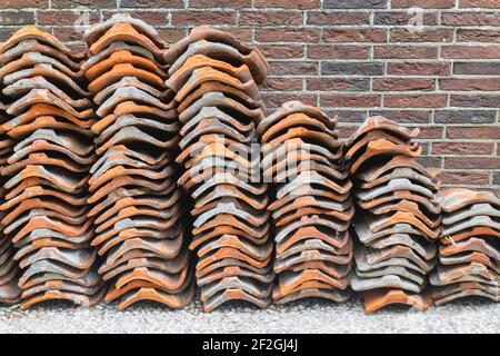 Stacked old roof tiles used for renovation on a Dutch construction site Stock Photo