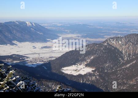 Winter hike through the mountain forest to the Simetsberg. Germany, Bavaria, Walchensee, Einsiedl, mountain view of Eschenlohe and the Murnauer Moos Stock Photo