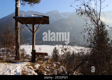 Walk in Eschenlohe, Europe, Germany, Bavaria, Upper Bavaria, Werdenfelser Land, winter, resting place, bench with canopy, atmospheric, shrub in the foreground Stock Photo