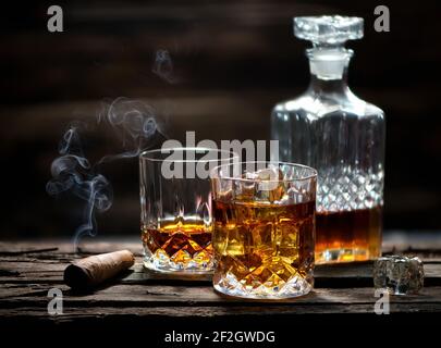 Cigar and glass with whiskey with ice cubes Stock Photo