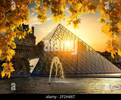 PARIS, FRANCE - AUGUST 26, 2016. Clouds over illuminated pyramid and museum of Louvre in the evening