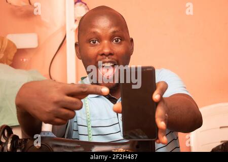 a tailor pointing to his mobile phone Stock Photo
