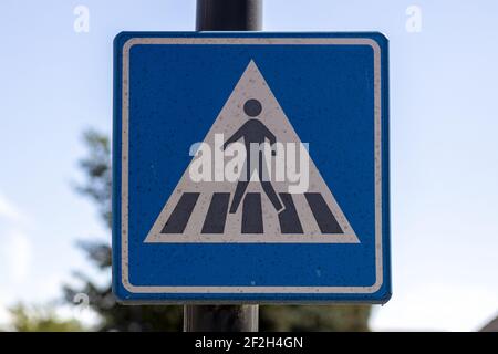 WIERDEN, NETHERLANDS - Sep 10, 2020: Traffic sign showing a figure crossing a zebra pathway with out of focus tree and blue sky in the background Stock Photo