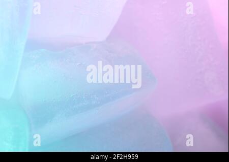 Macro of ice blue cube on blurred colorful background Stock Photo