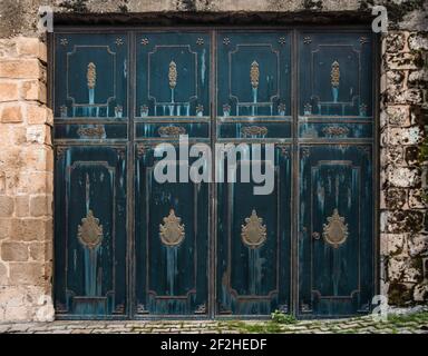 Four-section steel door in a stone brick wall. Stock Photo