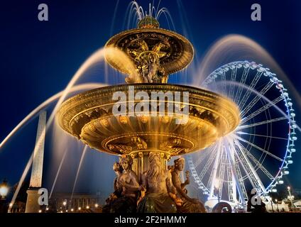 Fountain of Mars and ferris wheel on square of Concorde in evening Paris, France Stock Photo
