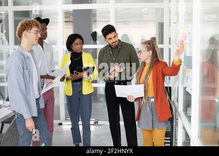 Multiracial students with gadgets having discussion at office Stock Photo