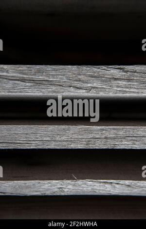 Faded, parallel wooden slats against a black background Stock Photo