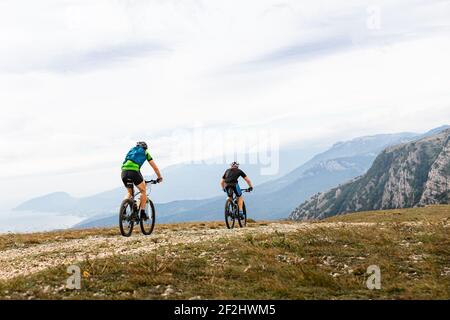 two male cyclists biking on mountain road Stock Photo