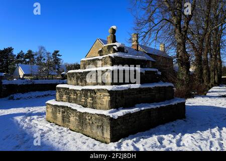 Winter snow over the market cross, Bainton village, Cambridgeshire England UK Stock Photo