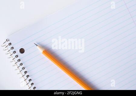 Striped blank notebook and pencil. Spiral notepad and orange pencil. Stock Photo