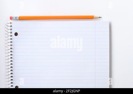 Striped blank notebook and pencil. Spiral notepad and orange pencil. Stock Photo