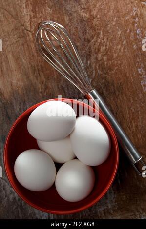 Beautiful White Eggs with Stainless Steel Wisk on Weathered Wood Vertical Stock Photo
