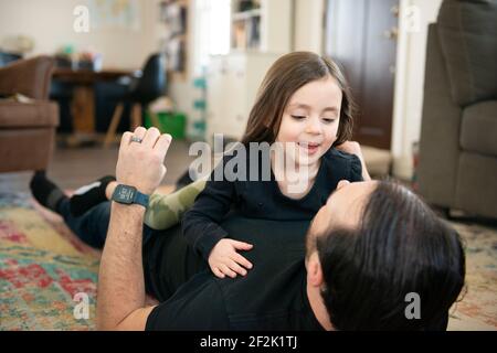 Father and daughter playing on the floor. Stock Photo