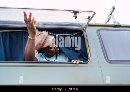 black african american man inside his camper van at the window