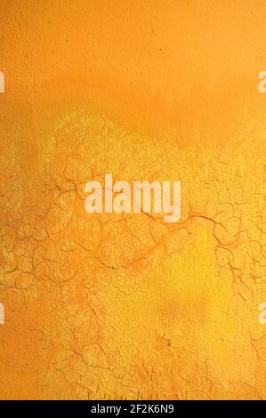 Textured Background of Yellow Cracking Paint on a Concrete Wall Vertical Stock Photo