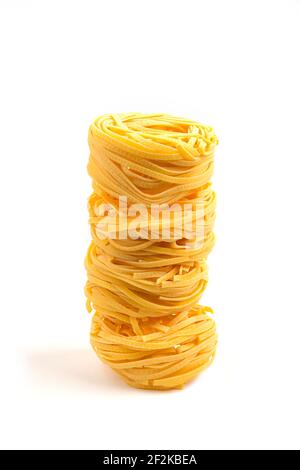 Three uncooked pasta nests on white background Stock Photo