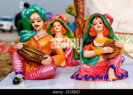 Beautiful handmade dolls of miniature villagers performing their daily chores is displayed in a shop for sale in blurred background. Indian handicraft Stock Photo