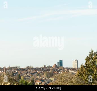 Looking over the tops of houses and Leicester city centre skyline, tower blocks, St. George’s Tower, with Charnwood Forest in the distance.