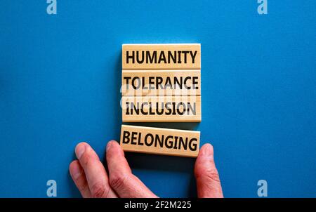 Humanity, tolerance, inclusion, belonging symbol. Wooden blocks with words humanity, tolerance, inclusion, belonging on beautiful blue background. Tol Stock Photo