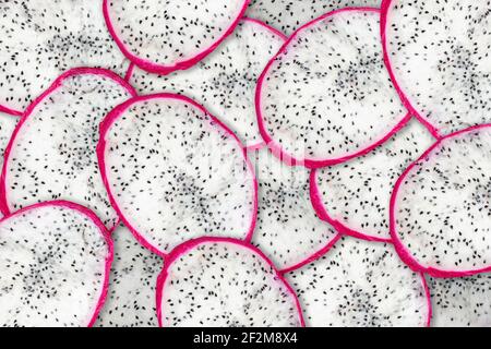 Sliced pitahaya dragon fruit fresh with white pulp and black seeds, compilation background. texture pattern of fruit pitaya. Stock Photo