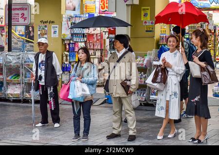 Japanese pedestrians waiting to cross a street, Kyoto, Japan Stock Photo