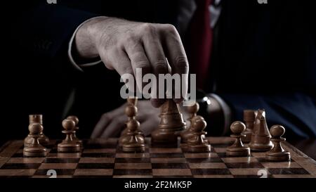 Strategy and business planning concept. A businessman at a chessboard in front of lined up white and black pawns. Strategy and tactics, battle readine Stock Photo