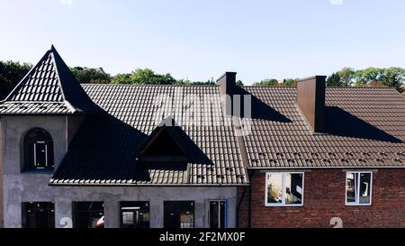 Aerial view of the new brown tiled roof with a weather vane. Stock Photo