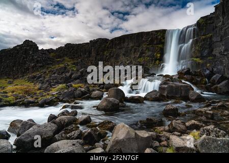 thingvellir National Park Iceland. Famous waterfall long exposure on a partly cloudy day Stock Photo