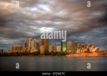 View on the Opera House and Sydney CBD from the Sydney Harbour, early in the morning with a cloudy sunrise. PHOTO : CHRISTOPHE LAUNAY / DPPI Stock Photo