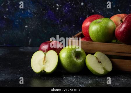 Wooden box of ripe organic apples on black background Stock Photo
