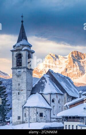 the antique village of Vinigo with the church of St. John Baptist and the mount Pelmo in background, winter view, Vodo di Cadore, province of Belluno, Veneto, Italy Stock Photo