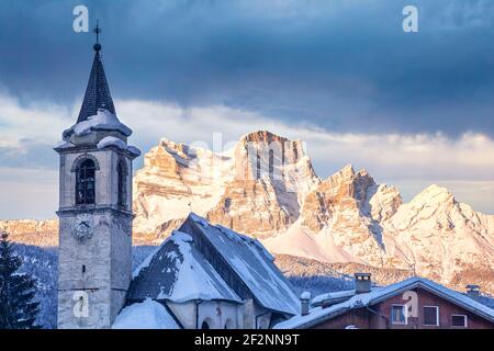 the antique village of Vinigo with the church of St. John Baptist and the mount Pelmo in background, winter view, Vodo di Cadore, province of Belluno, Veneto, Italy Stock Photo