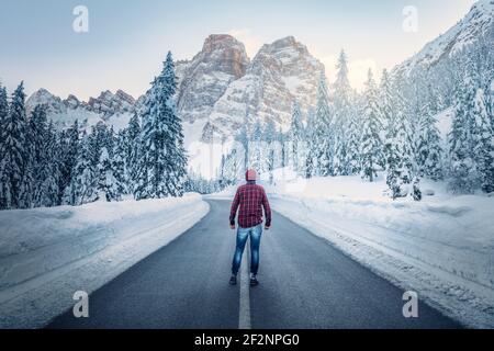 road of the staulanza pass with the pelmo in the background. man alone in the middle of the roadway. Fiorentina valley, Selva di Cadore, Belluno, Veneto, Italy Stock Photo