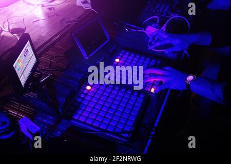 DJ playing synthesizer and mixing music in the night club. Stock Photo