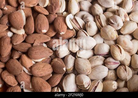 Close-up of a plate full of almonds and the other half with pistachios. Nuts and healthy eating. Stock Photo