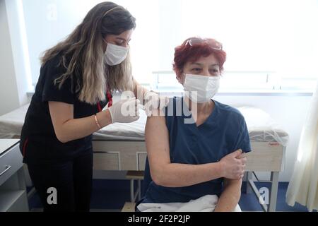 Ankara, Turkey. 12th Mar, 2021. A woman receives the COVID-19 vaccine in Ankara, Turkey, on March 12, 2021. Turkey reported on Friday 14,941 new COVID-19 cases, including 834 symptomatic patients, as the total number of positive cases in the country reached 2,850,930, according to its health ministry. Credit: Mustafa Kaya/Xinhua/Alamy Live News Stock Photo