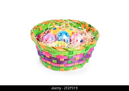 Colourful Easter eggs with polka dots in a basket, isolated on white background. Easter celebration concept. Stock Photo