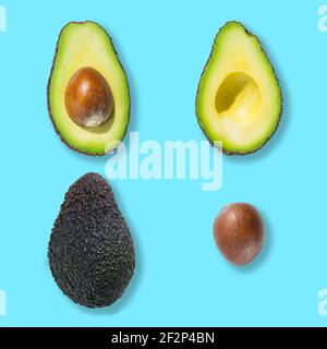 Top view of fresh ripe whole avocado fruit, cut in half and bone isolated on blue background Stock Photo