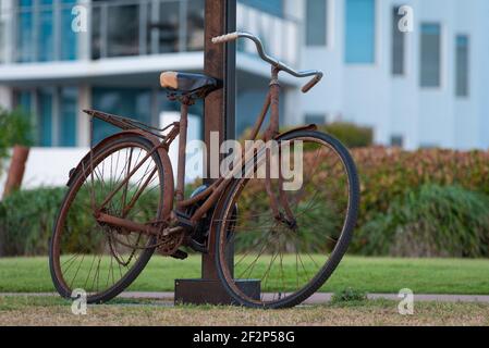 An old rusty bicycle leans up against a lamp post Stock Photo