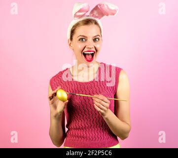 Happy Easter. Smiling woman painting egg. Happy girl in bunny ears painted egg. Stock Photo