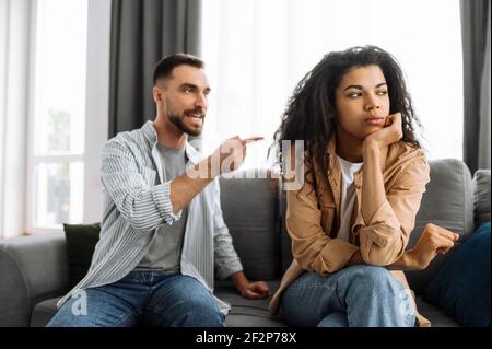 Married young couple emotional discuss about something, they having problem. African american woman and caucasian man disagree with each other have a misunderstanding, cant make decision, a quarrel Stock Photo