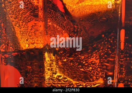 Cola in glass with ice and a bubbles of gas. Macro photo. Stock Photo