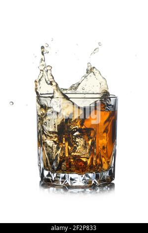 Glass with whiskey splash isolated on white background. Stock Photo