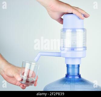 Hand water pump. Water pump for home and office use, isolated on white background. Drinking Water bottles with manual pump dispensers. Stock Photo