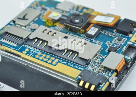 Disassembled mobile phone or smartphone. Circuit board, camera, microcircuit, slots for sim cards. Macro photo. Stock Photo