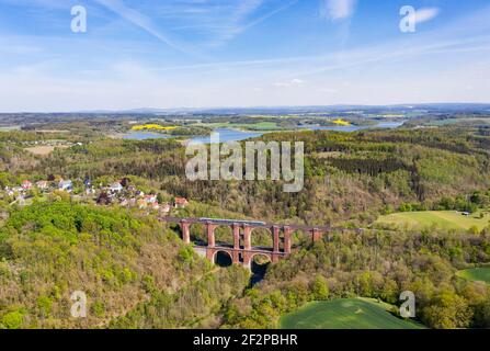 Brick arch bridge (279 m long, 68 m high), second largest of its kind in the world, train, houses, forest, valley, lake Stock Photo