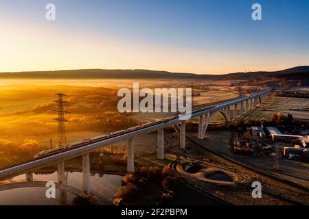 ICE, longest bridge in Thuringia (1681 m long, 48 m high), high-voltage pylons, power line, morning mood, aerial view Stock Photo